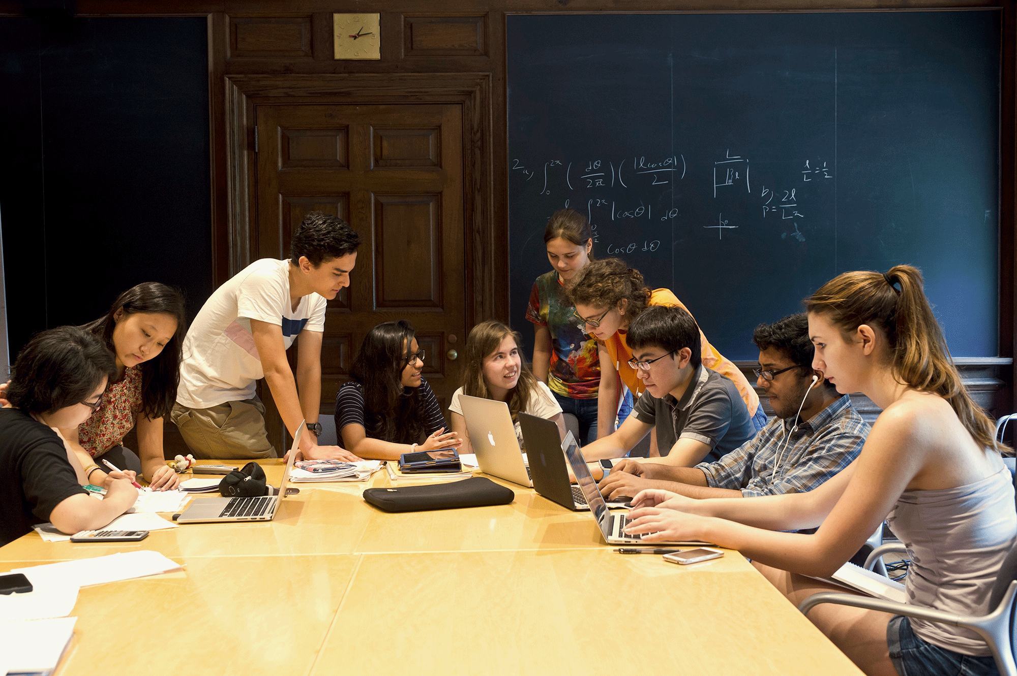 Students gather around a table in a physics class at Harvard Summer School.