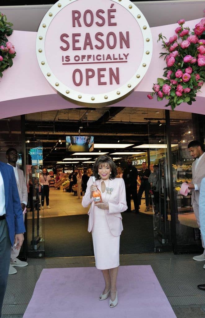 Joan collins holding rosé outside M&S