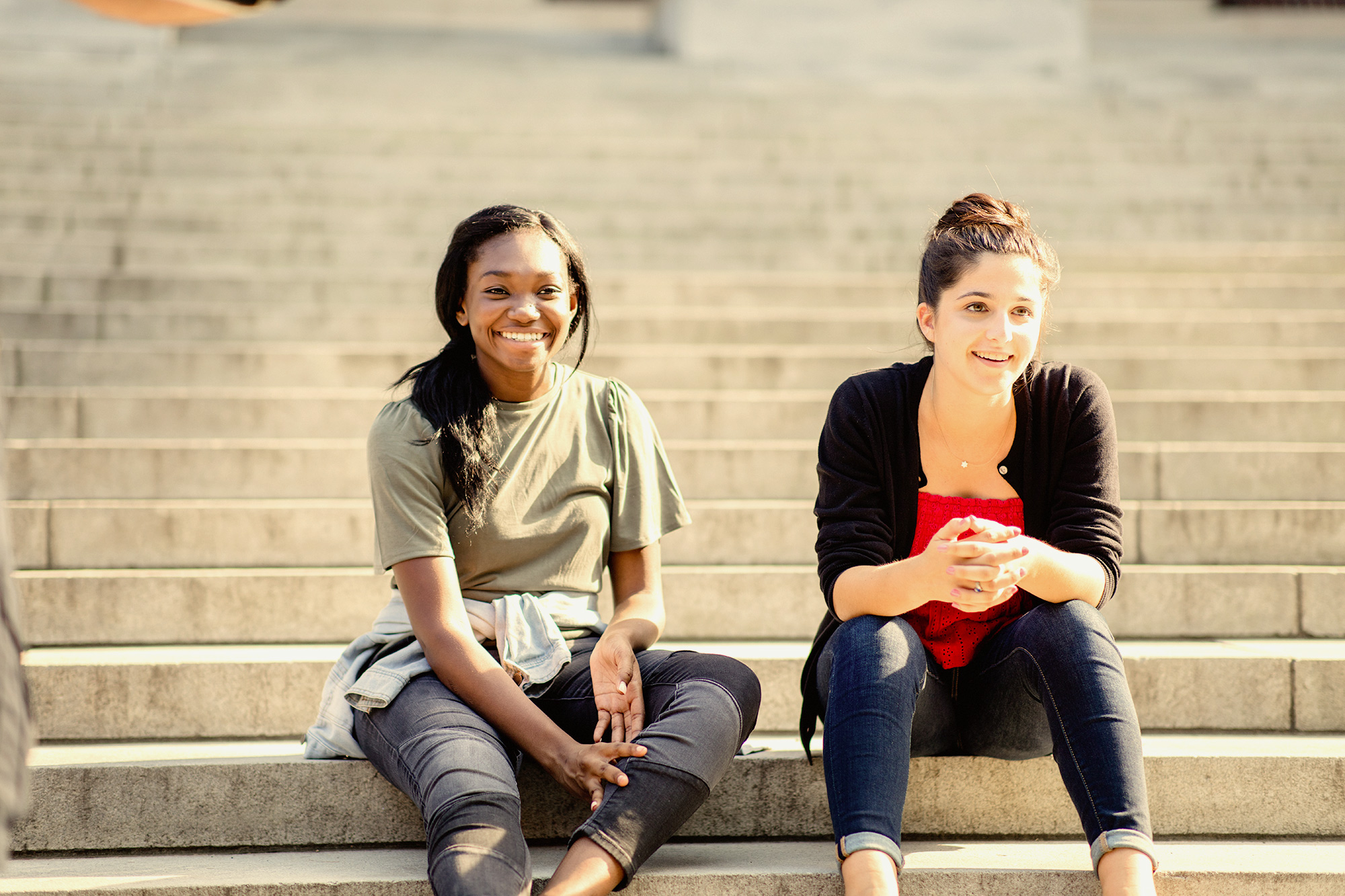 two high school females sitting on library steps at Harvard