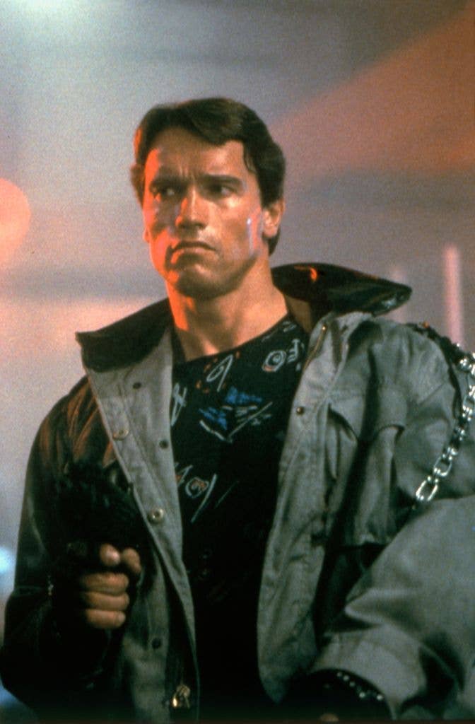 Arnold Schwarzenegger in a large green jacket over a dark jumper as Terminator in film The Terminator.