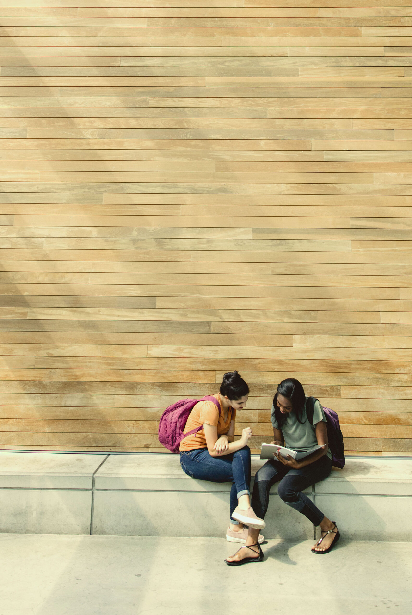 2 female students sitting down looking at book