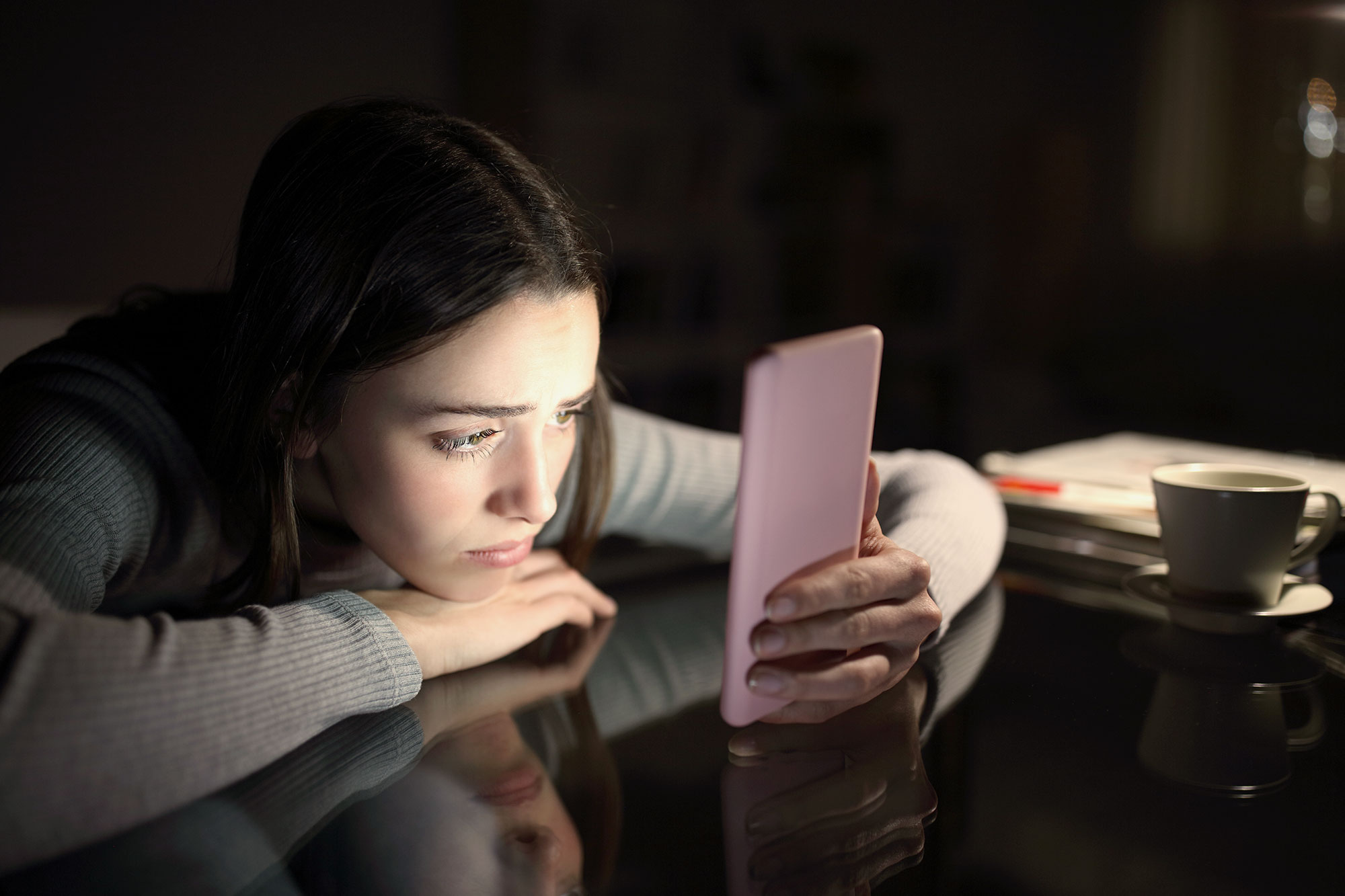 Girl looking sadly at phone.