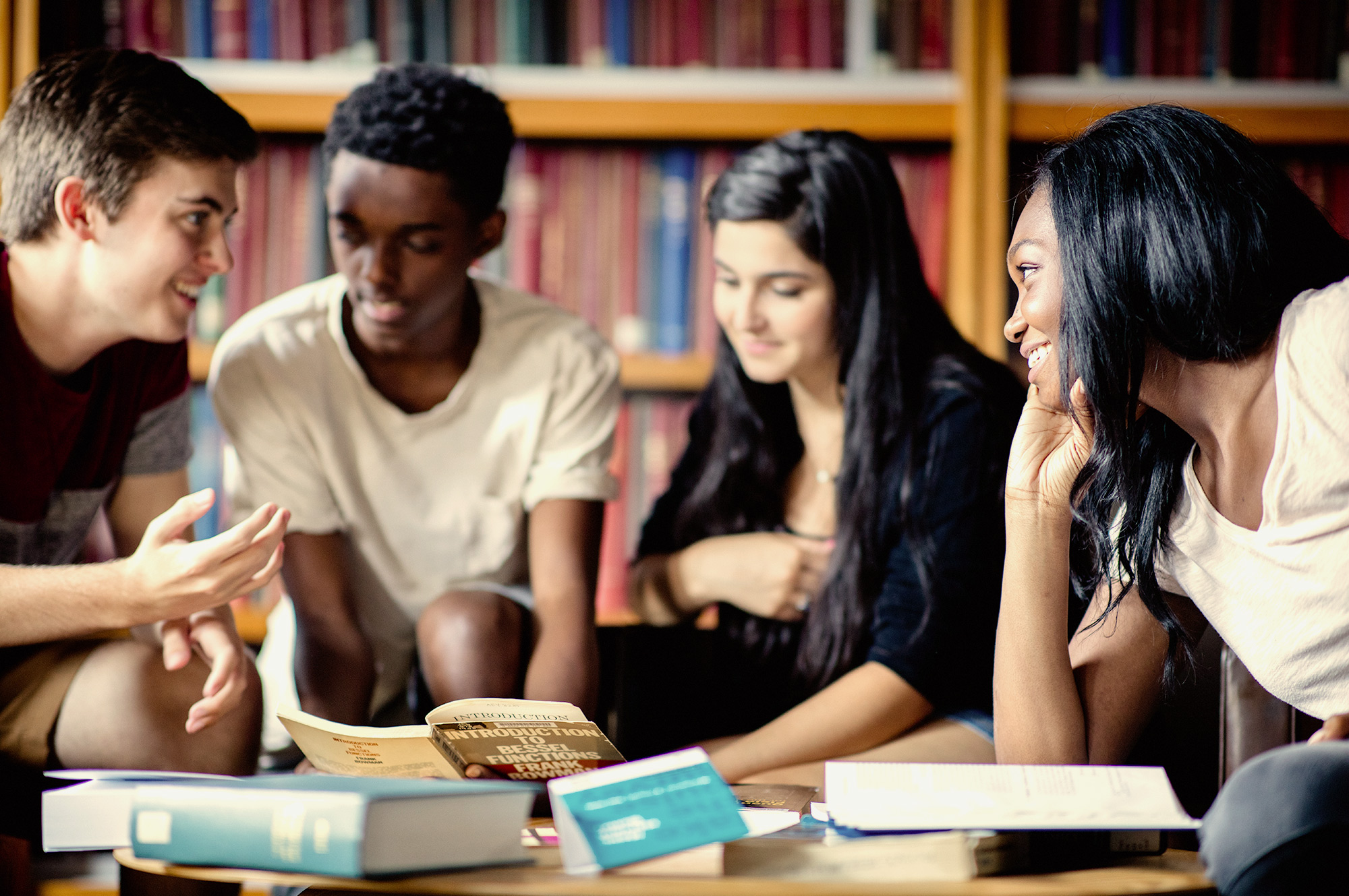 four students inside Harvard library